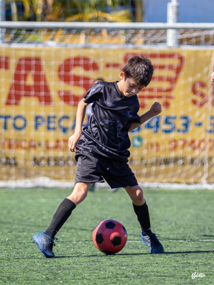 Aluno conduzindo a bola durante treino da União Academy